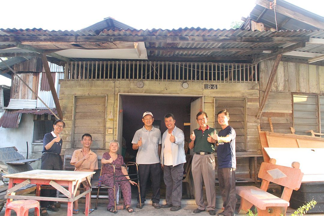 完成修缮屋子后，陈婵娇（左一）及志工们与照顾户林素清（左三）、儿子许伟雄（左二）一起合照。 【摄影：卢俊辉】