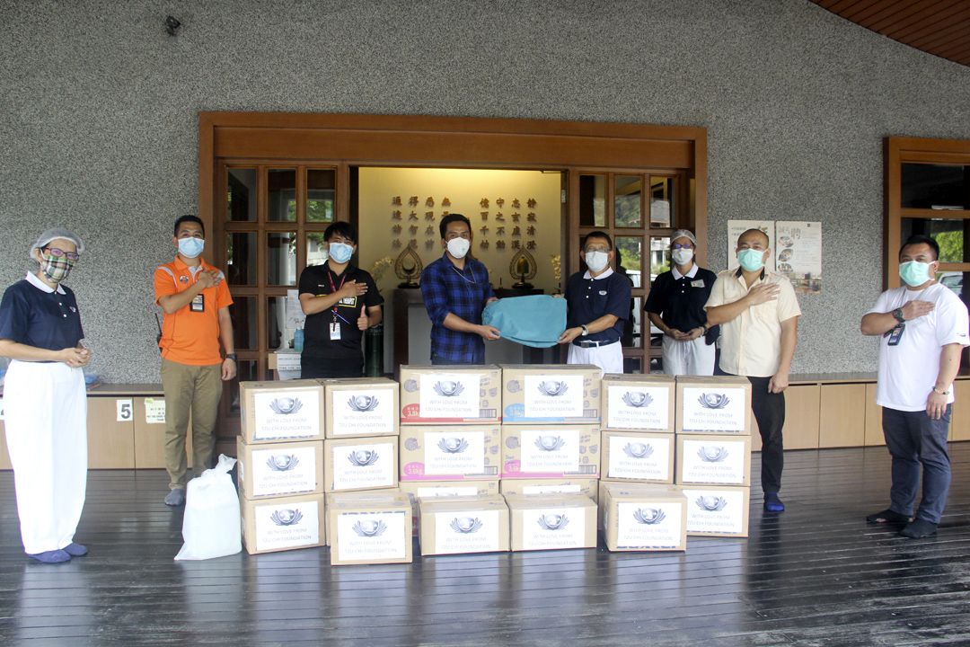 志工把防护物质递给医护人员并送上满满的祝福。莫哈末阿兹林医生（左四）及医护人员沃利丹尼尔（左三）感恩慈济制作防护装备于院方。 【摄影：谢念祥】