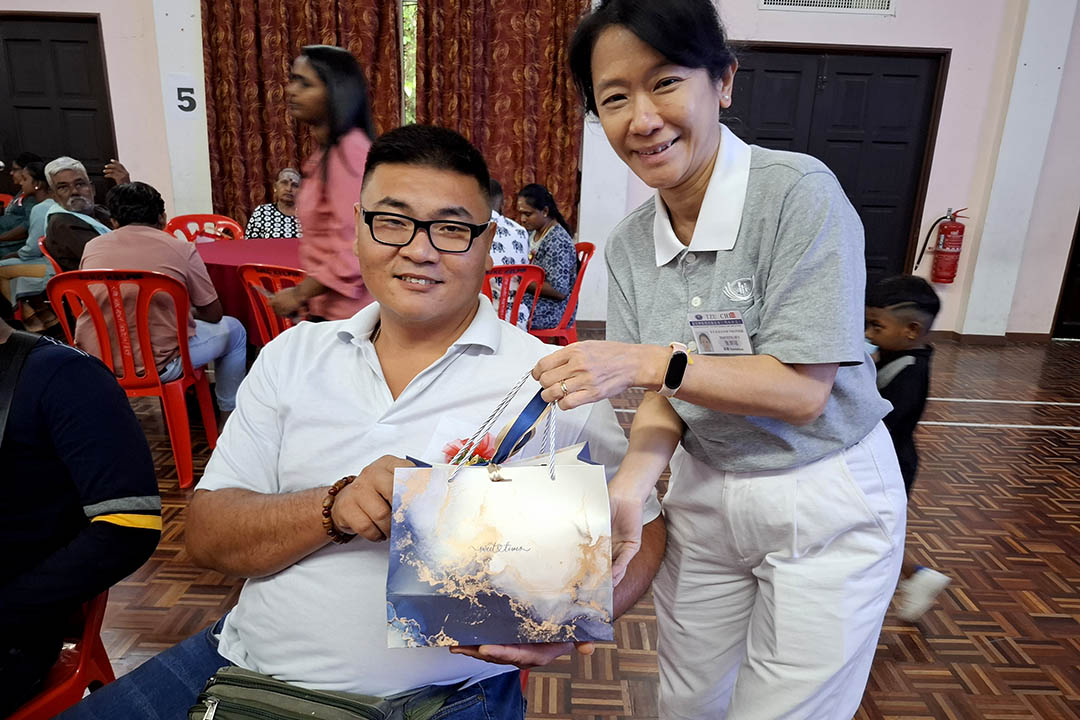 慈济志工送上礼包给照顾户，祝福大家欢喜迎新年。图为林天才（左）的开心都写在脸上，更有勇气面对挑战。【摄影：黄秀珍】