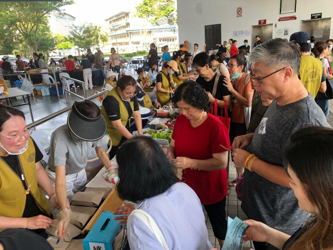 您开心采买、我欢喜付出！民众围在摊位前开心选购，志工们一边包装、一边招呼，手没停过、笑容也没停过。热闹的场面，让人真切感受到社区的温暖与力量。 【摄影：林青萤】	