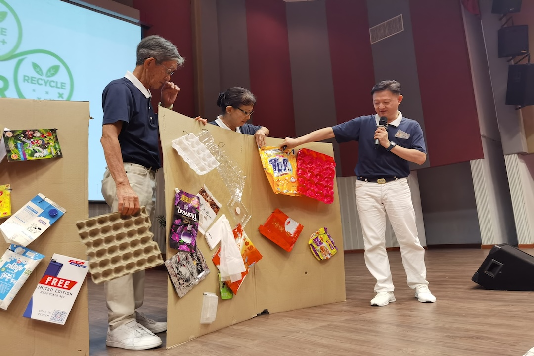 志工刘志胜（右）为大家讲解可以回收及不能回收的物品。【摄影：谢念祥】