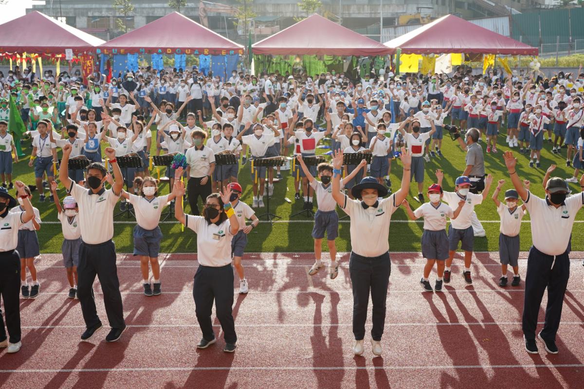 2022年小学组运动会开幕礼上，师生们舞动身体做热身运动。【摄影：伍诗昱】