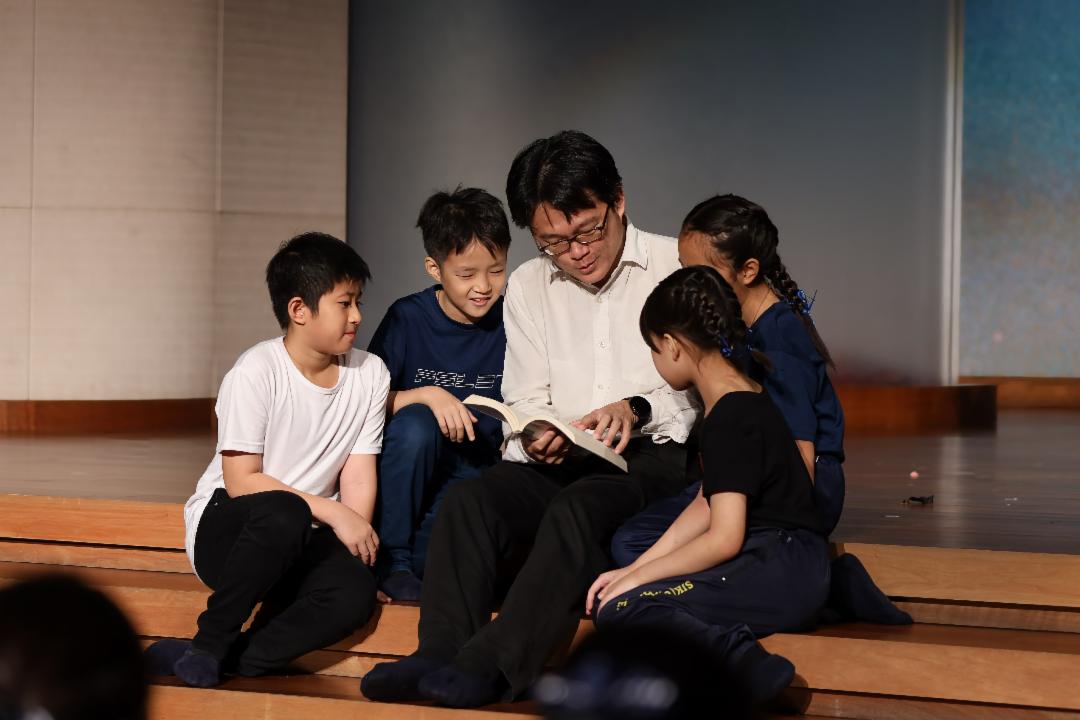 一书一语，父爱流露；一听一笑，孩子成长，亲子慈少圆缘尽显亲情之美。【摄影：陈世权】