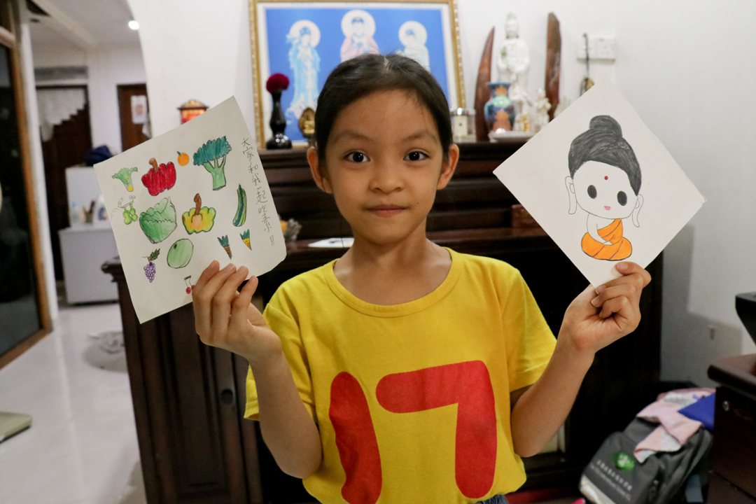八岁的斐柔静在5月26日卫塞节当天，亲手绘画劝素卡和佛陀法像，她要祝贺佛陀生日快乐外，也要做劝素小天使。 【摄影：杨文辉】