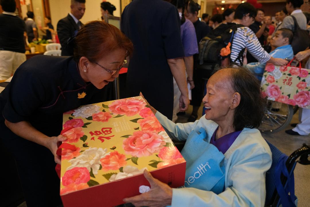 送上礼盒的当儿，也一并把祝福送上，让感恩户满载温馨的记忆而归。 【摄影：林振胜】