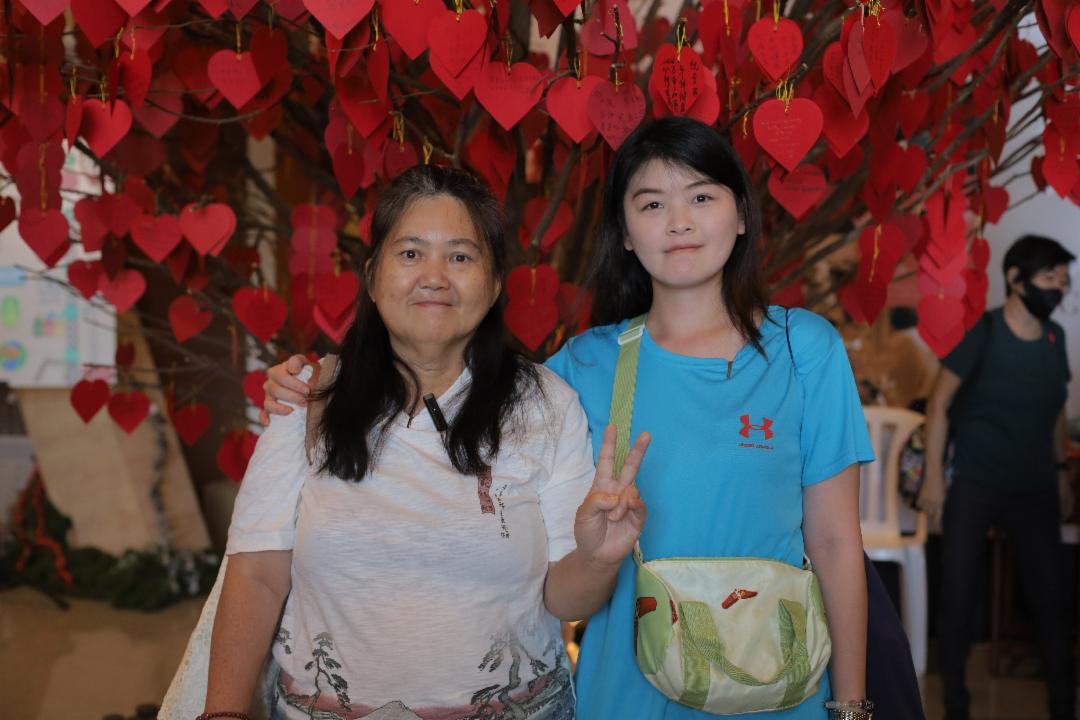 李玉萍（左）多年都邀女儿蔡家欢（右）参加岁末祝福。女儿每次都不得空，这次，终于可以陪伴前来，让李玉萍开心地比了个V的手势。 【摄影：庄贵贺】