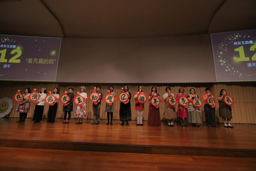 十五位妆容亮丽的癌友，在舞台上展示“慈济癌友互助会12周年庆”的牌子，自信满满地展现出“最亮丽的我”。 【摄影：庄贵贺】