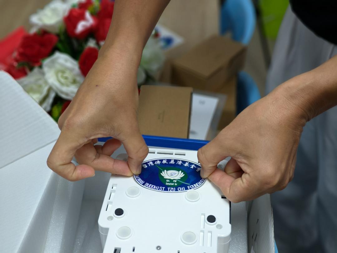 十台便携式洁牙机及十台痰液吸引器上贴有慈济标志，象征此次援助的关怀。【摄影：许明扬】